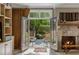 Bright living room featuring a fireplace and French doors opening to the outdoor patio area at 92 Old Ivy Ne Rd # 6, Atlanta, GA 30342