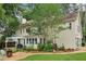 A sprawling backyard with a yellow two-story home, stone patio, and lush landscaping, perfect for outdoor gatherings at 2965 Village Dr, Marietta, GA 30062