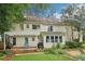 A backyard showcases a yellow two-story home with a stone patio, pergola, and lush landscaping at 2965 Village Dr, Marietta, GA 30062