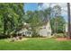 Expansive backyard featuring a lush lawn, patio area with seating, and mature trees providing shade and privacy at 2965 Village Dr, Marietta, GA 30062