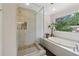 Modern bathroom with a glass-enclosed shower, soaking tub, and large window at 2965 Village Dr, Marietta, GA 30062