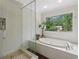 Beautiful bathroom featuring a soaking tub, glass shower, and large window overlooking the yard, offering privacy at 2965 Village Dr, Marietta, GA 30062