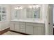 Bathroom with double sinks, bright light fixtures, and hardwood floors for a spa-like experience at 2965 Village Dr, Marietta, GA 30062