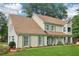 Classic two-story home featuring light siding, green shutters, a well-manicured lawn, and lovely landscaping at 2965 Village Dr, Marietta, GA 30062