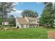 Charming two-story home boasts a lush lawn, garden, and inviting exterior with light yellow siding and green shutters at 2965 Village Dr, Marietta, GA 30062