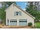 Two car detached garage with matching siding, green shutters, and doors that add to the charm of the property at 2965 Village Dr, Marietta, GA 30062