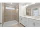 Bright bathroom featuring a tiled shower with glass doors and a double sink vanity at 706 Smokey Quartz Way, Kennesaw, GA 30144