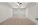 A spacious main bedroom is enhanced with a tray ceiling, ceiling fan, and two windows at 706 Smokey Quartz Way, Kennesaw, GA 30144