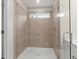A tiled shower with a window and glass doors at 706 Smokey Quartz Way, Kennesaw, GA 30144