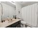 Bright bathroom featuring a single sink vanity, toilet, and shower with curtain at 146 Sunset Ln, Woodstock, GA 30189