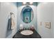 Powder room features a black granite sink with a blue accent wall and a mirror at 146 Sunset Ln, Woodstock, GA 30189