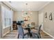 Dining room features a glass table with gray chairs, modern chandelier, and stylish decor at 146 Sunset Ln, Woodstock, GA 30189