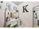 Vanity with makeup mirror, white chair, drawers, and pink accent wall with decor at 146 Sunset Ln, Woodstock, GA 30189