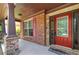 Inviting front porch showcasing brick accents, a red door, and stone columns, providing a warm welcome at 2532 Gloster Mill Drive Southwest, Lawrenceville, GA 30044