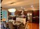 Modern kitchen with stainless steel appliances, granite countertops, dark wood cabinets, and a chandelier over the dining area at 2532 Gloster Mill Drive Southwest, Lawrenceville, GA 30044