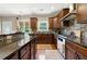 Well-equipped kitchen featuring dark wood cabinetry, granite countertops, and mosaic backsplash for modern appeal at 2532 Gloster Mill Drive Southwest, Lawrenceville, GA 30044