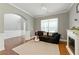 Bright living room with a fireplace, stylish sofa, and guitar, complete with archway and natural light at 2532 Gloster Mill Drive Southwest, Lawrenceville, GA 30044