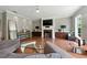 Bright living room with a fireplace, large TV, hardwood floors, and stylish decor, creating a cozy atmosphere at 2532 Gloster Mill Drive Southwest, Lawrenceville, GA 30044