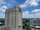 Beautiful high-rise building with blue skies and lush greenery in a park setting at 3040 Peachtree Nw Rd # 1713, Atlanta, GA 30305