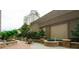 An outdoor condominium patio featuring a fountain, lush landscaping, and seating with a grill at 3040 Peachtree Nw Rd # 1713, Atlanta, GA 30305