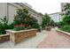 Condominium outdoor patio with lush greenery, a built-in grill, and multiple seating areas for residents at 3040 Peachtree Nw Rd # 1713, Atlanta, GA 30305