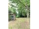 Spacious backyard featuring mature trees, wooden shed and a stone path at 3604 Orchard Cir, Decatur, GA 30032
