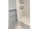 Bathroom features a white tub, tile surround, storage shelves, and chrome fixtures at 3604 Orchard Cir, Decatur, GA 30032