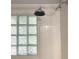 White-tiled shower featuring a glass block window and chrome shower head at 3604 Orchard Cir, Decatur, GA 30032