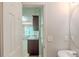 View from the powder room into the kitchen with stainless appliances and dining area beyond at 513 Shadow Valley Ct, Lithonia, GA 30058