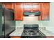 Kitchen showcasing stainless steel appliances and cherry-stained wood cabinets at 513 Shadow Valley Ct, Lithonia, GA 30058