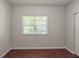 Simple, empty bedroom with wood-look floors and a window at 5341 Terrytown Ln, Lithonia, GA 30038