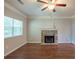 Unfurnished living room featuring hardwood floors, a ceiling fan, and a stone fireplace at 5341 Terrytown Ln, Lithonia, GA 30038