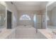 Bright bathroom featuring a soaking tub, a arched window, and double sinks at 901 Chadwick Park Dr, Lawrenceville, GA 30045