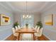Bright dining room featuring hardwood floors, elegant lighting, and neutral decor at 901 Chadwick Park Dr, Lawrenceville, GA 30045