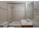 Tiled bathroom featuring a shower-tub combo, toilet, single vanity, and a mirror at 2245 Dauphine St, Atlanta, GA 30344