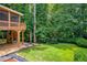 Spacious backyard featuring a raised screened-in porch and steps to the yard at 3795 Newport Bay Dr, Alpharetta, GA 30005