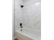 Bathroom featuring a sleek white tub with marble-like tile surround and modern black fixtures at 3795 Newport Bay Dr, Alpharetta, GA 30005