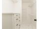 Bright walk-in closet features white walls, marble tile flooring, shelving and custom drawer storage at 3795 Newport Bay Dr, Alpharetta, GA 30005