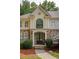Close-up of a home's entrance with stone accents, a covered doorway, and tasteful landscaping that frames the facade at 3795 Newport Bay Dr, Alpharetta, GA 30005