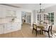 Open kitchen with white cabinetry, subway tile backsplash, and dining area leading to the living room at 3795 Newport Bay Dr, Alpharetta, GA 30005