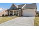 A well-maintained home features beautiful stone detailing, a two-car garage, and a neatly kept lawn at 5120 Token Chase, Cumming, GA 30040