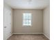Bedroom featuring neutral carpet, walls, and a window looking out to the front yard at 5207 Shawn Ln, Stone Mountain, GA 30088