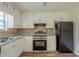 Well-lit kitchen features white cabinets, stainless steel appliances, and durable vinyl flooring at 5207 Shawn Ln, Stone Mountain, GA 30088