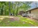 Large backyard with a detached storage shed, mature trees, and a brick house in the background at 1105 Buckhurst Dr, Atlanta, GA 30349