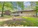 Backyard with a wooden deck attached to a brick house, surrounded by mature trees at 1105 Buckhurst Dr, Atlanta, GA 30349