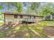Backyard view of a brick house with a wooden deck surrounded by mature trees and foliage at 1105 Buckhurst Dr, Atlanta, GA 30349