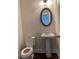 Elegant half bath with pedestal sink, oval mirror, and modern fixtures at 1250 Winterhaven Dr, Cumming, GA 30041