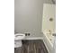 Clean bathroom with wood-look flooring and shower with white tiling at 3800 Leisure Ln, Atlanta, GA 30349