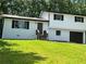 A charming two-story home with freshly painted brick and a lush green lawn in a wooded area at 3800 Leisure Ln, Atlanta, GA 30349