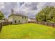 Side view of a spacious backyard with a wooden fence and ample green space at 440 Pinevale Ct, Atlanta, GA 30349